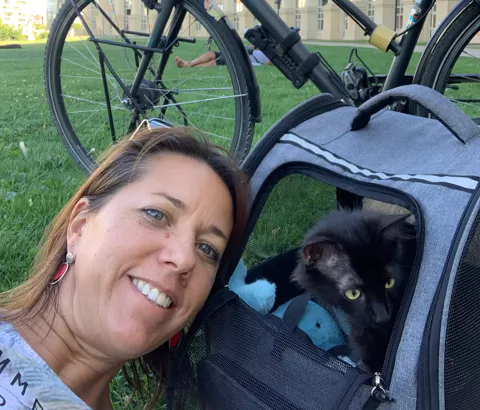 Aline Claret assise avec son chien, moment complice et chaleureux.